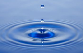 water drops hitting the surface of water in a pool