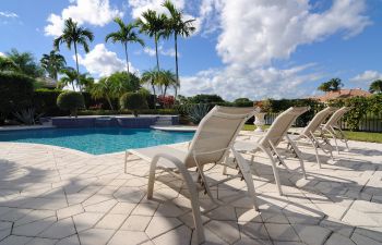 Pool cleaning and maintenance equipment on the edge of a swimming pool deck.