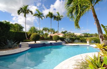 Pool cleaning and maintenance equipment on the edge of a swimming pool deck.