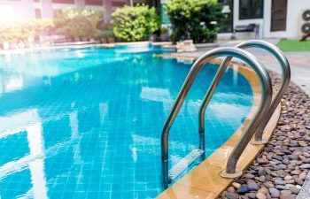 Backyard pool with hot tub and paver patio.