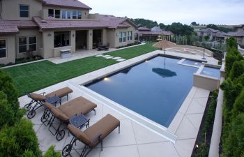 A pool with natural stone decking in a backyard
